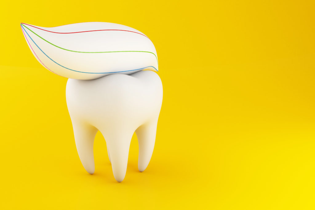 Ząb i pasta na żółtym tle - fluor.